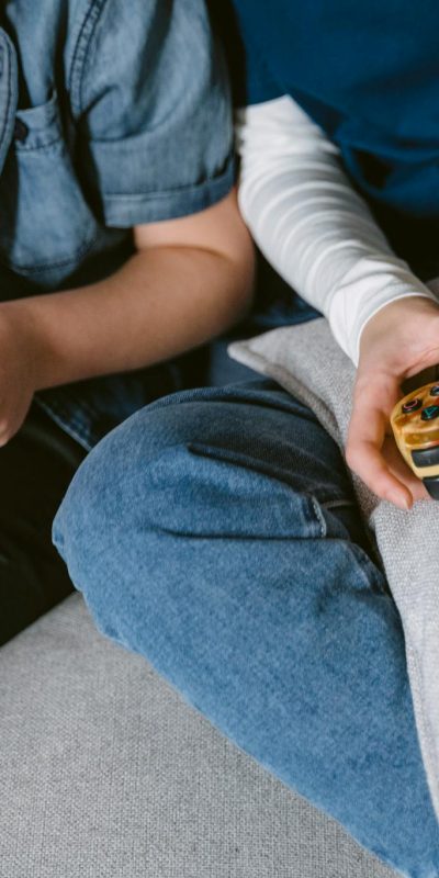 Two teenagers absorbed in console gaming indoors, focused on controllers.